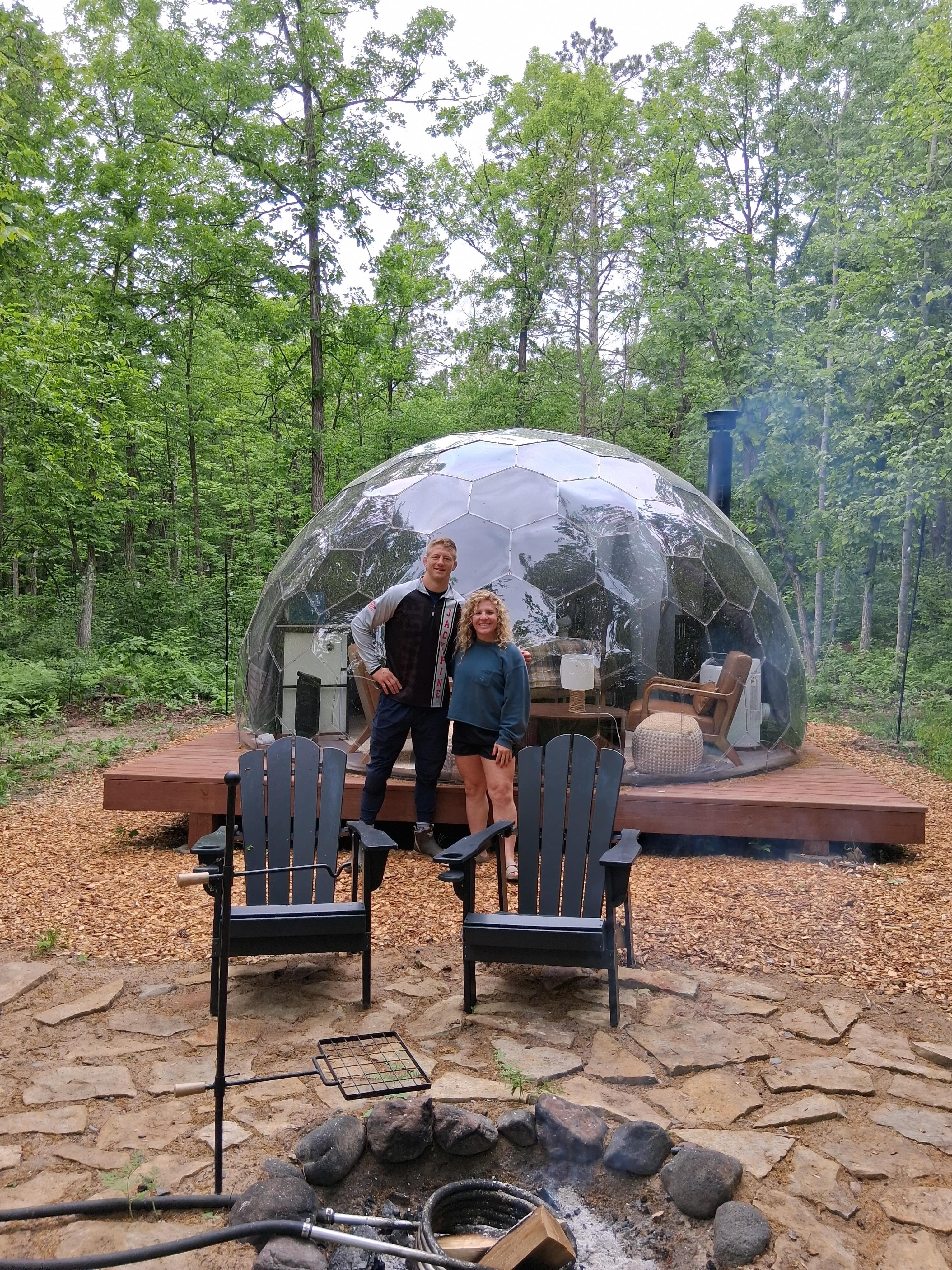 Two guests inside a geodesic mirror dome at Cuyuna Crossing