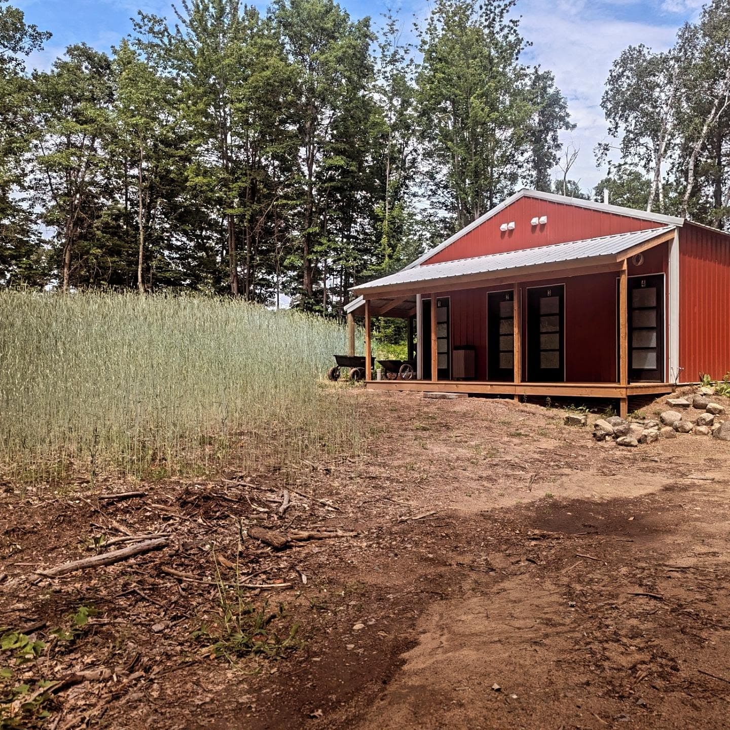 Red cabin with large windows and wooden deck at Cuyuna Crossing